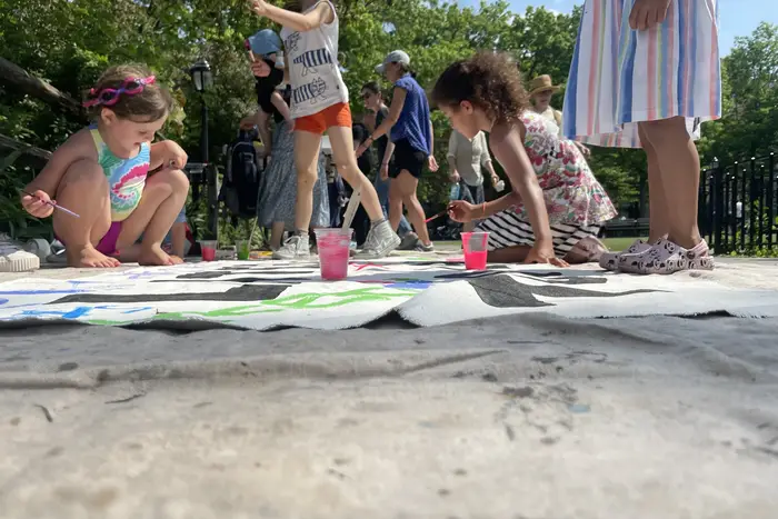 Children decorate a banner that reads "Later is too late" during a recruitment playdate for Sunrise Kids at JJ Byrne Playground in Park Slope, Brooklyn, May 22nd, 2022.